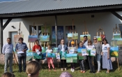 Uczestnicy pleneru malarskiego obok swoich prac