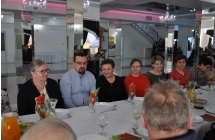 Szesc kobiet oraz mezczyzna siedza przy stole