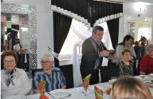 Mezczyzna robi zdjecie telefonem, przy stole siedza kobiety