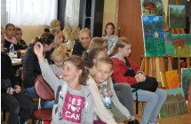 Usmiechniete dzieci na tle wystawy obrazow