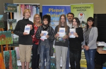 Trojka dziewczyn i mlody mezczyzna pozujacy z dyplomami