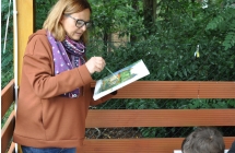 Kobieta malujaca obraz, ktory trzyma w dloni