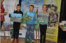 Dwoje chlopczykow i dziewczynka z obrazami pejzazy