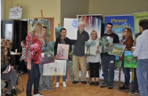 Dorosli na tle sztalug z obrazami