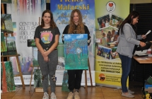 Dwie dziewczyny w dlugich wlosach prezentujace obraz