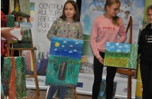 Dwie dziewczynki przy sztalugach ze swoimi obrazami