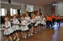 Czworo chlopcow oraz dziewczynki ubrane w biale spodniczki w czasie tanca