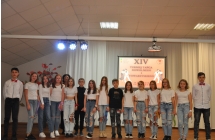 Czworo chlopcow i kilkanascie chlopcow pozujacych do zdjecia na scenie