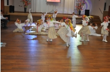 Dzieci w ludowych strojach prezentujace uklad taneczny