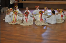 Dziewczynki w ludowych strojach siedzace w kolku