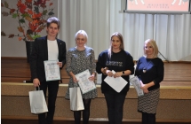 Mezczyzna i trzy kobiety pozujace do zdjecia z dyplomami