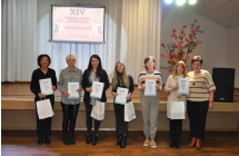 Siedem kobiet pozujacych do zdjecia z dyplomami